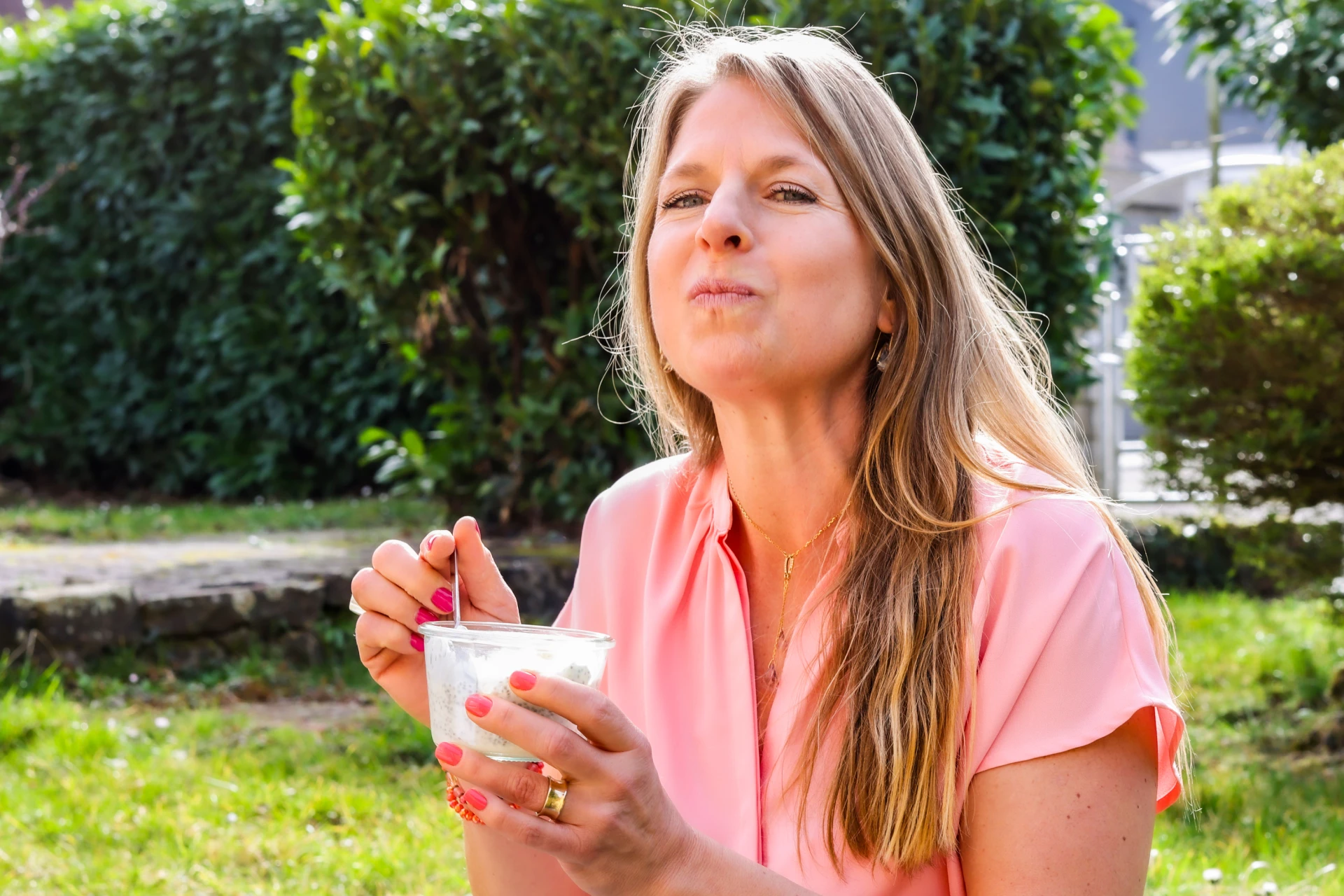Nina Veit Ernaehrungscoach aus Heidelberg sitzt im Garten und isst Quark aus einem Glas zur Vorbereitung auf den Sugar Reset Online Videokurs